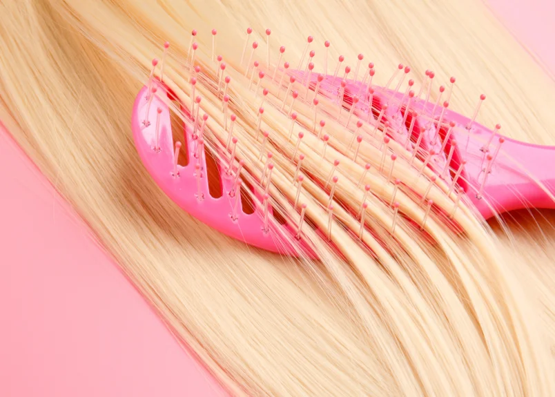 Blonde hair on pink hair brush