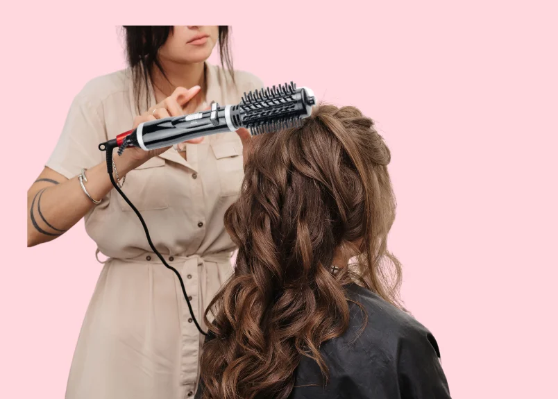 Woman with curly hair, woman with blow dryer brush 