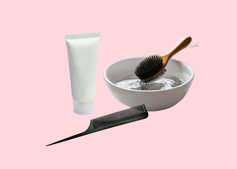 Natural hair cleanser, comb and boar bristle brush in a bowl of water