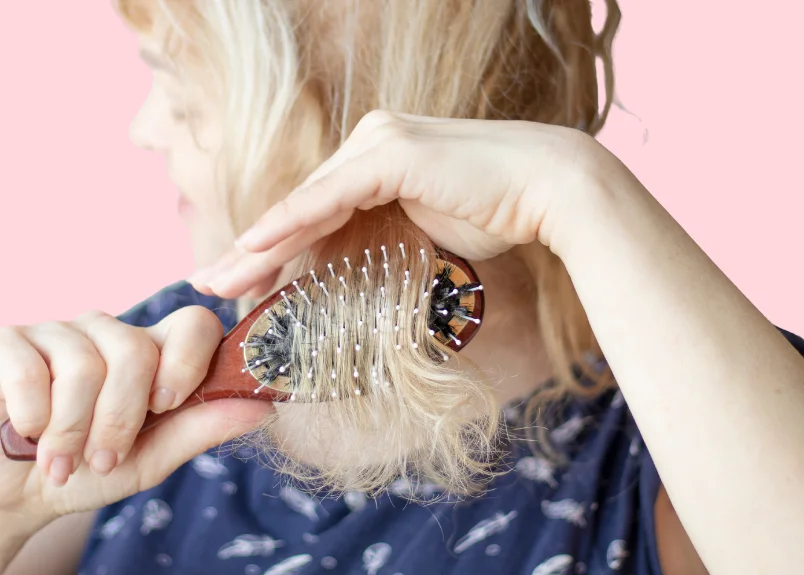 Woman brushing tangled hair