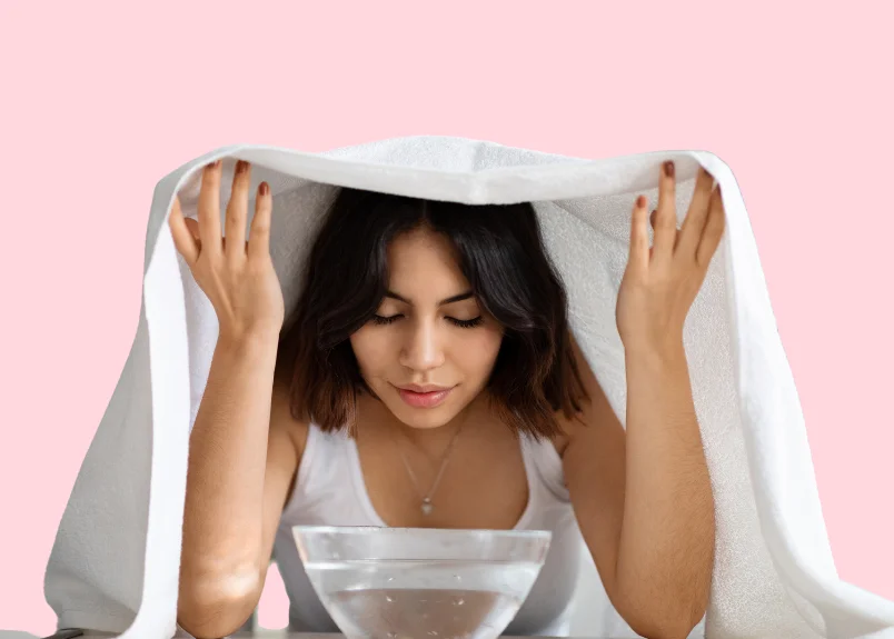 Woman with towel on head and a bowl of staming water