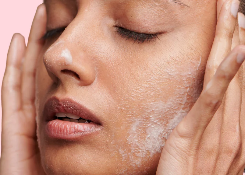 Woman applying skincare on face