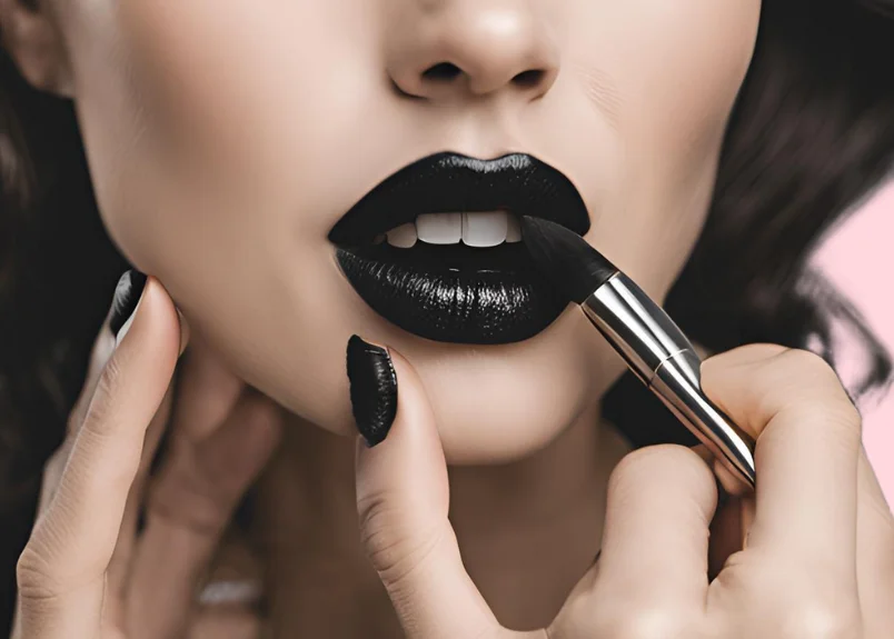 Beautiful woman applying black lipstick on lips