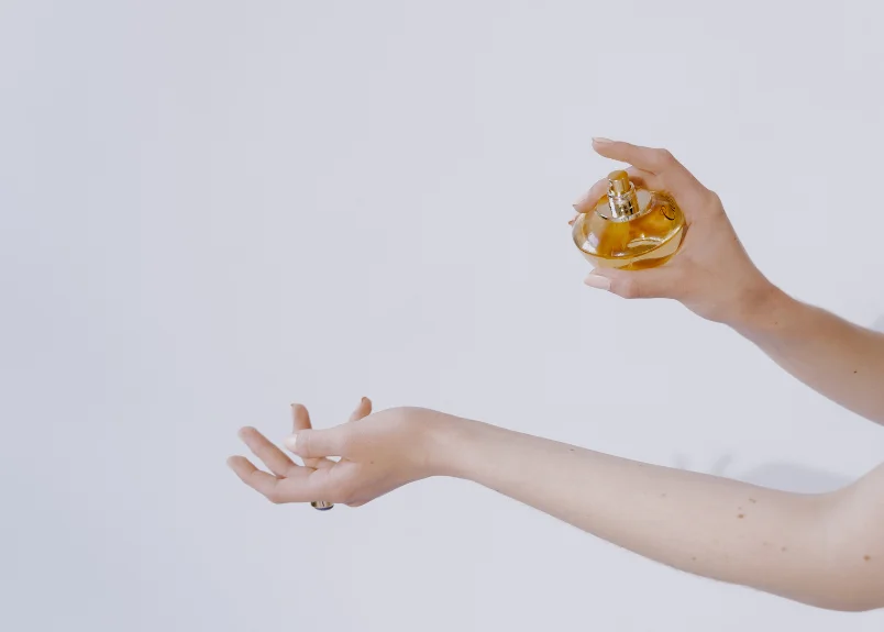 Woman applying perfume oil on wrists